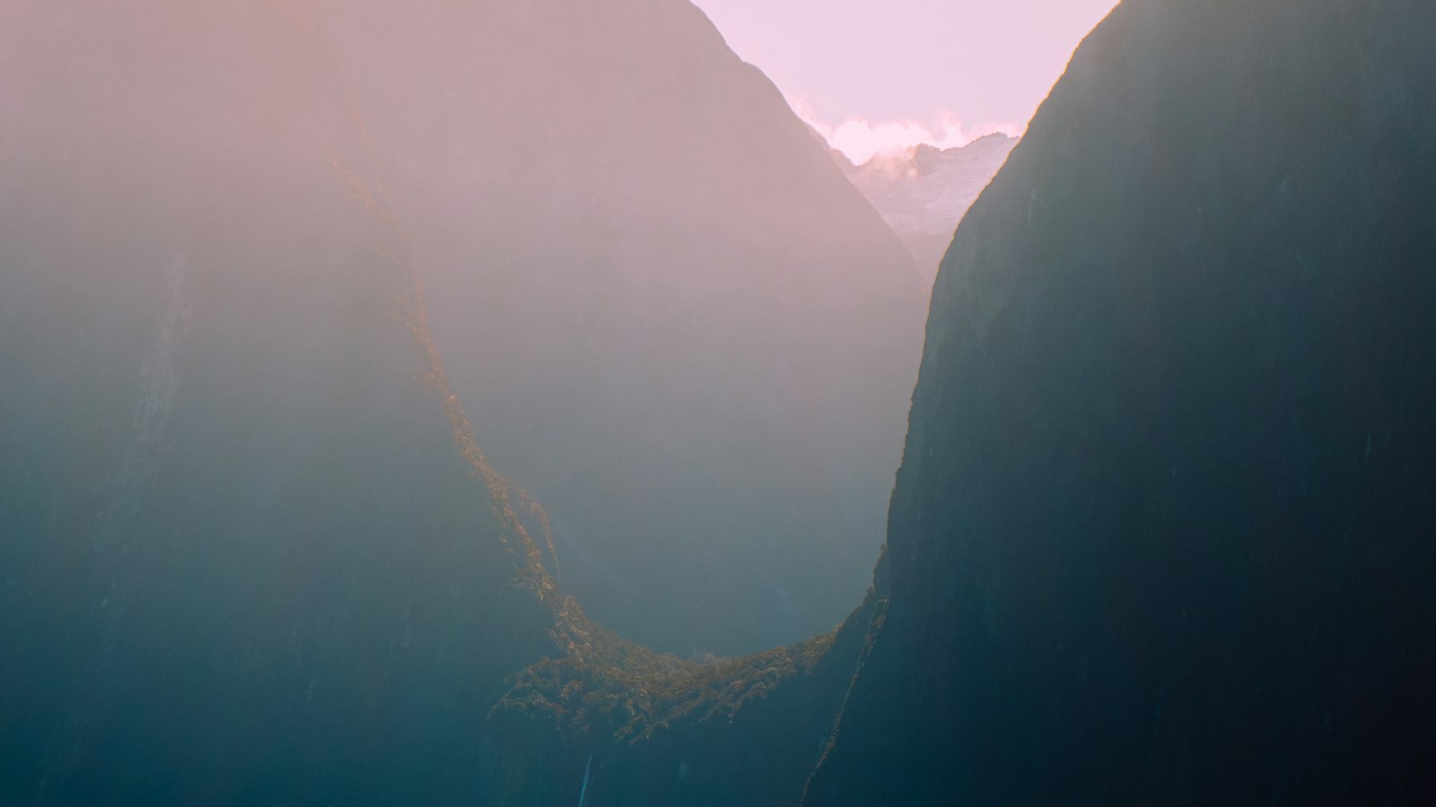Misty mountains and calm water at sunrise