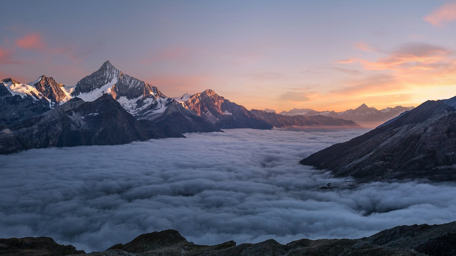 Mountain range silhouetted under a colorful dusk sky